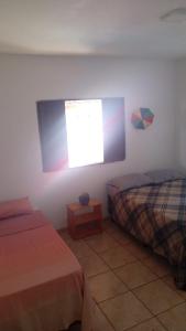 a bedroom with two beds and a window at Sol guest house in Pipa