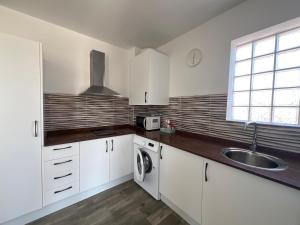 a white kitchen with a sink and a washing machine at Villas Privadas EL DESCANSO in La Rinconada