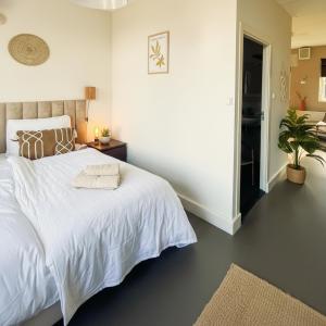 a bedroom with a white bed and a potted plant at Family Retreat Zoutelande Beach in Zoutelande