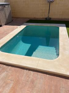 a swimming pool with blue water in a yard at Villas Privadas EL DESCANSO in La Rinconada