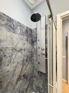 a shower in a bathroom with a marble wall at Le Porte di Parma in Parma +32 photos