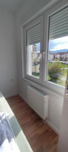 パレにあるStan na dan Višnjaの2つの窓とラジエーターを備えた白い寝室