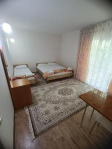 une petite chambre avec deux lits et une table dans l'établissement Issyk-Kul Cozy Cottage, à Rybpunkt 102 autres photos