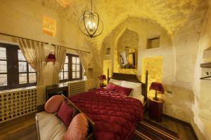 una camera da letto con un letto e un divano in una stanza di Zerzembe Boutique Hotel a Şanlıurfa