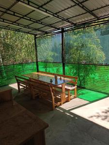 une table de ping-pong avec deux bancs dans un pavillon dans l'établissement Issyk-Kul Cozy Cottage, à Rybpunkt