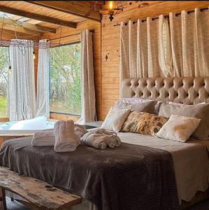 a large bed in a room with a large window at Cabana na Tree in Urubici