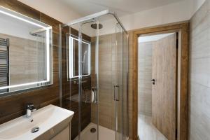 a bathroom with a sink and a shower with a glass door at Mlýn Herlíkovice in Hořejší Vrchlabí +133 photos