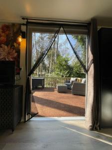 拉纳肯The Butterfly - Forest - Dog - Maastricht的带露台的客厅里有一扇敞开的滑动玻璃门