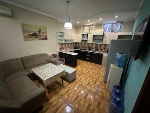 ein Wohnzimmer mit Couch und Küche in der Unterkunft House of Timur in Buxoro