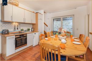 a kitchen and dining room with a wooden table and chairs at Ferienanlage am Gothensee 25 Rad Kapitän in Bansin