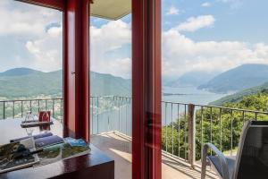 um quarto com uma varanda com vista para a água em Hotel Serpiano em Serpiano