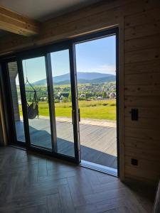 an open sliding glass door with a view of a porch at Barn&Haus-Stodoły Widokowe in Zubrzyca Dolna