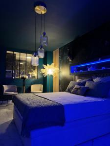 een slaapkamer met een groot bed met blauwe verlichting bij Flower Suite & Spa, air-conditioned and beach in La Seyne-sur-Mer