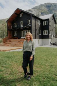 a woman standing in the grass in front of a house at Villa Fjellheim in Luster