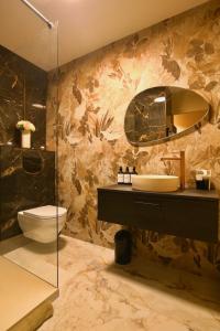 een badkamer met een wastafel, een toilet en een spiegel bij Flower Suite & Spa, air-conditioned and beach in La Seyne-sur-Mer +13 foto's