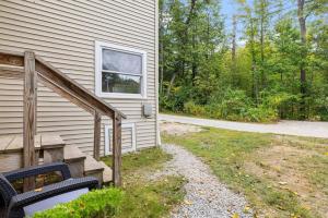 a house with a bench next to a building at Comfy Large Bungalow - 4 Bed 1BA On Private Pond in Bradford