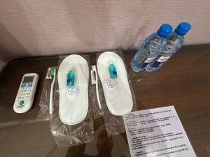 einen Tisch mit zwei Fernbedienungen und zwei Flaschen Wasser in der Unterkunft House of Timur in Buxoro