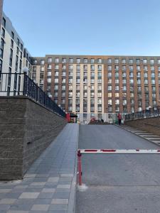 eine leere Straße vor einem großen Gebäude in der Unterkunft Уютная квартира на центре города, возле EXPO in Astana