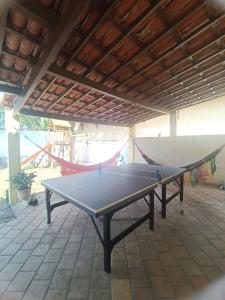 une table de ping-pong sur une terrasse avec un hamac dans l'établissement Sol guest house, à Pipa