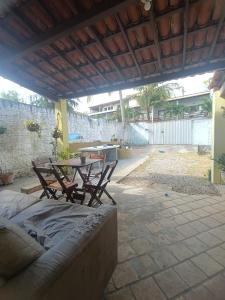 un patio avec une table, des chaises et un canapé dans l'établissement Sol guest house, à Pipa