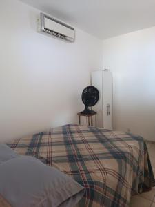 - une chambre avec un lit, une couverture et un ventilateur dans l'établissement Sol guest house, à Pipa