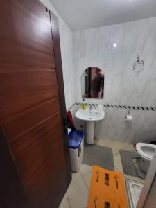 a bathroom with a toilet and a sink and a door at Cabo dream in Cabo Negro