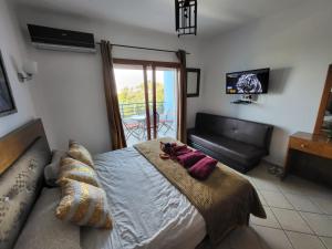 a bedroom with a bed and a couch and a television at Cabo dream in Cabo Negro +4 photos