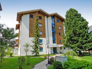 a large building with trees in front of it at Apartment Metropol B by Interhome in Grächen