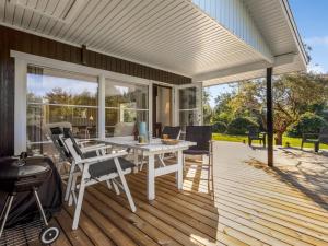 an outdoor patio with a white table and chairs at Holiday Home Tameran - 1km from the sea by Interhome in Gedesby