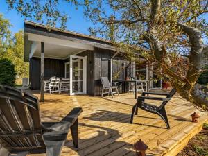 a wooden deck with two chairs and a table at Holiday Home Tameran - 1km from the sea by Interhome in Gedesby