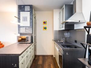 a kitchen with white cabinets and black appliances at Apartment Morgensonne B1105 by Interhome in Rhens