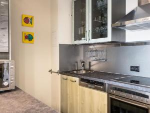 a kitchen with wooden cabinets and a sink at Apartment Morgensonne B1105 by Interhome in Rhens