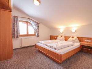 a bedroom with a large bed and a window at Apartment Voithofer-5 by Interhome in Königsleiten
