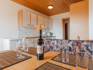 a bottle of wine sitting on a table with wine glasses at Apartment Voithofer-3 by Interhome in Königsleiten