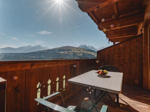 a table on the balcony of a cabin with a view at Apartment Voithofer-3 by Interhome in Königsleiten