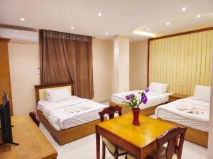 a hotel room with two beds and a table at Grand Pyramid View Hotel in Cairo