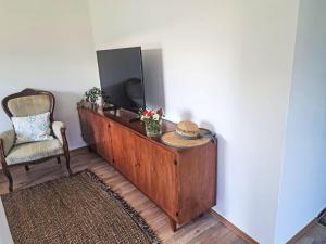 a room with a television on a dresser with a chair at Villa Villa Rose by Interhome in Nachdemsee