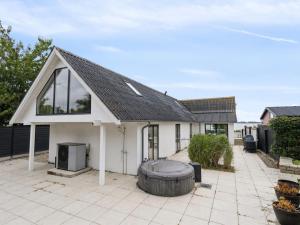a white house with a large tire in front of it at Holiday Home Rusalina - 20m from the sea by Interhome in Balke