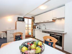 Una cocina con una mesa con un bol de fruta encima. en Apartment Plank-1 by Interhome, en Stumm