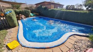 a swimming pool with blue water in a backyard at Riad Golden Baibah in Zaouia Akermoud