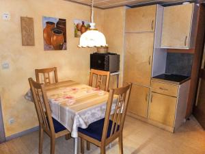 a kitchen with a table and chairs and a microwave at Apartment Landhaus Weisser by Interhome in Neudingen