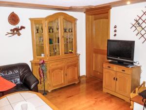 a living room with a television and a wooden hutch at Apartment Landhaus Weisser by Interhome in Neudingen +6 photos