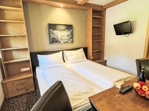 a bedroom with a bed and a desk with a table at Apartment Cheeky Apartment-4 by Interhome in Oberndorf in Tirol +6 photos
