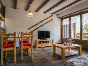 a living room with two chairs and a television at Apartment Centaure B 103 by Interhome in Ovronnaz