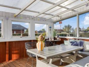 a patio with a table and chairs and windows at Holiday Home Ali - 500m from the sea by Interhome in Hejlsminde