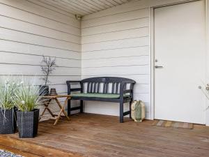 a black bench sitting on a porch next to a door at Holiday Home Ali - 500m from the sea by Interhome in Hejlsminde