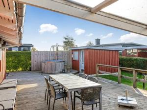 a patio with a table and chairs and a playground at Holiday Home Ali - 500m from the sea by Interhome in Hejlsminde