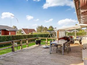 a wooden deck with a table and chairs on it at Holiday Home Ali - 500m from the sea by Interhome in Hejlsminde +16 photos