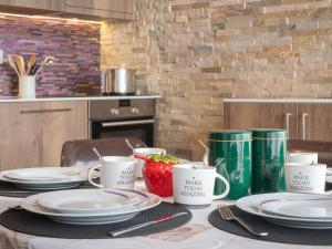 a table with plates and mugs on top of it at Apartment Centaure B CO 1 by Interhome in Ovronnaz