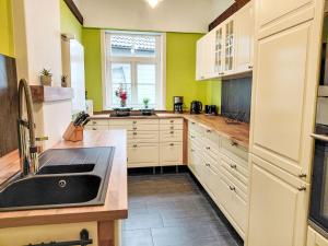 a kitchen with white cabinets and a black sink at Apartment Schwalenberger Land by Interhome in Schieder-Schwalenberg